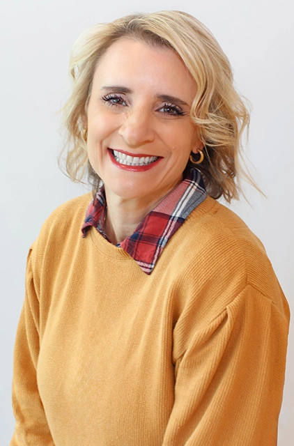 A woman with blonde hair and a yellow shirt.