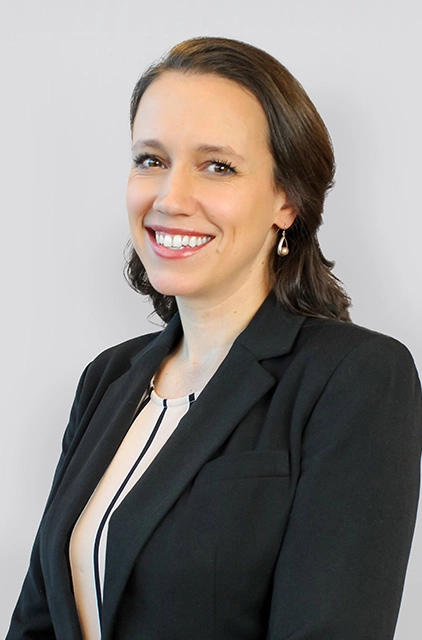 A woman in black jacket smiling for the camera.