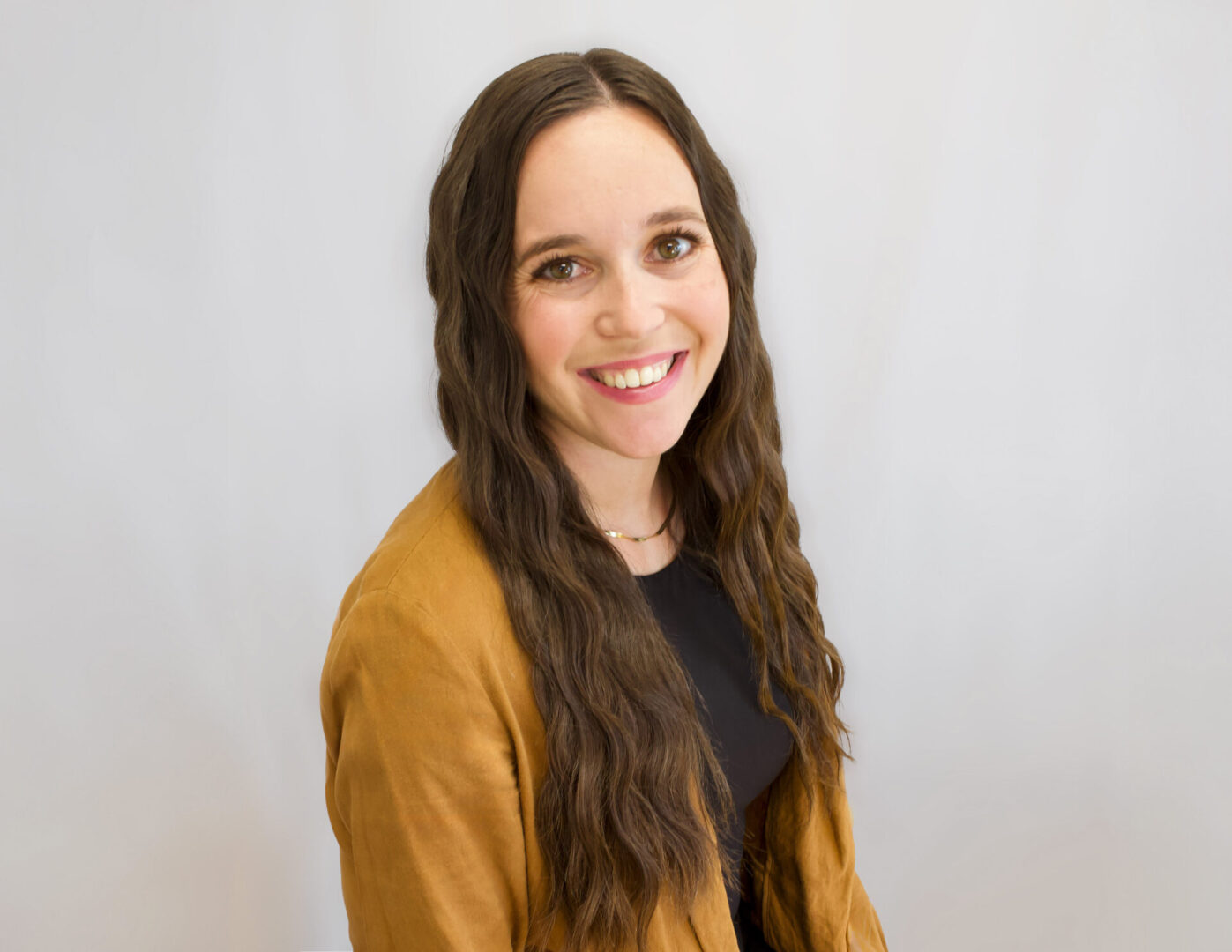 A woman with long hair is smiling for the camera.